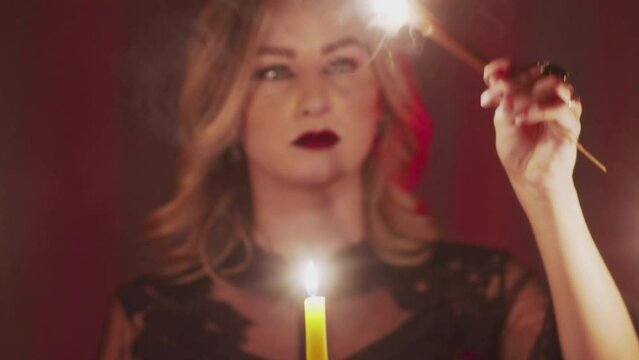 Female fortune teller holding a magic pendulum over photo of lost person