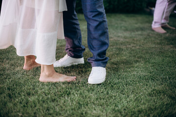 a couple of newlyweds are standing, legs in shoes close-up