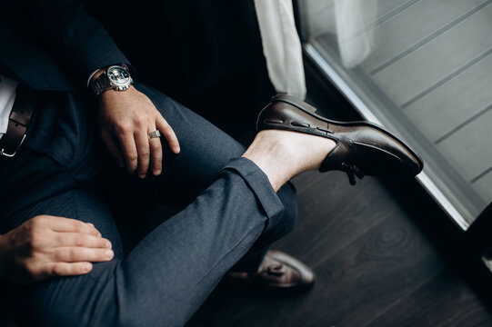 legs of a groom in a black suit in a hotel