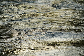 Wasser Oberfläche mit sich darin spiegelndem Sonnenlicht in stimmungsvoller Anmutung