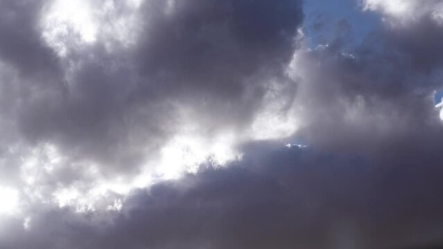 Dynamic cloudscape with huge cumulus clouds boiling and rolling across the sky