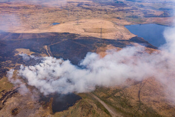 Aerial view of a huge wildfire on high level moorland next to a reservoir (Llangynidr Moors, Wales)