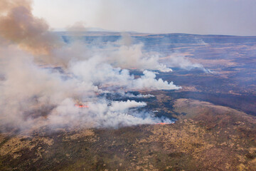 Aerial view of smoke and flames from a large grassfire on moorland in South Wales, UK (Llangynidr Moors)