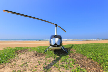 Helicopter Robinson R44 landed on the beach