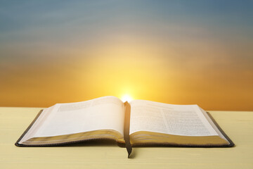 Open Holy Bible on table outdoors