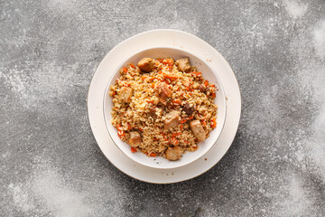 Plate of traditional pilaf on grunge background