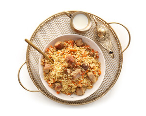 Tray with plate of traditional pilaf and Aladdin lamp on white background