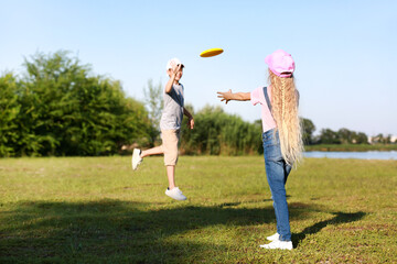 Cute little children playing frisbee outdoors