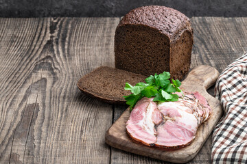 Pork brisket slices smoked meat on rye bread on wooden table