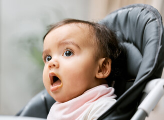 Can I have some more, please. Shot of an adorable baby girl sitting in her feeding chair.