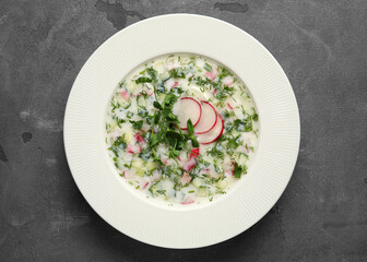 Plate with tasty okroshka on grunge background