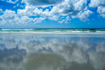 clouds over the reflective beach