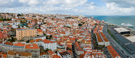Naklejka na ściany i meble Aerial view of Lisbon Alfama district. Plenty of traditional crowded antique residential houses with orange clay triangle roofs on the hill of Lisbon Portugal