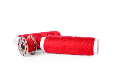 Red thread spools on white background