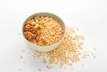 Fototapeta na wymiar Bowl of healthy oatmeal with nuts on white background
