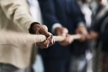 Working together to rope in success. Closeup shot of a group of unrecognizable businesspeople pulling together on a rope in an office. - obrazy, fototapety, plakaty