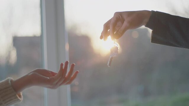 Women purchase a new modern apartment, taking the key from real estate agent, completed the deal and handshaking in slow-motion