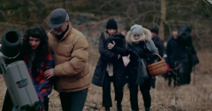 War Refugees With Luggage Helping Each Other In Forest.