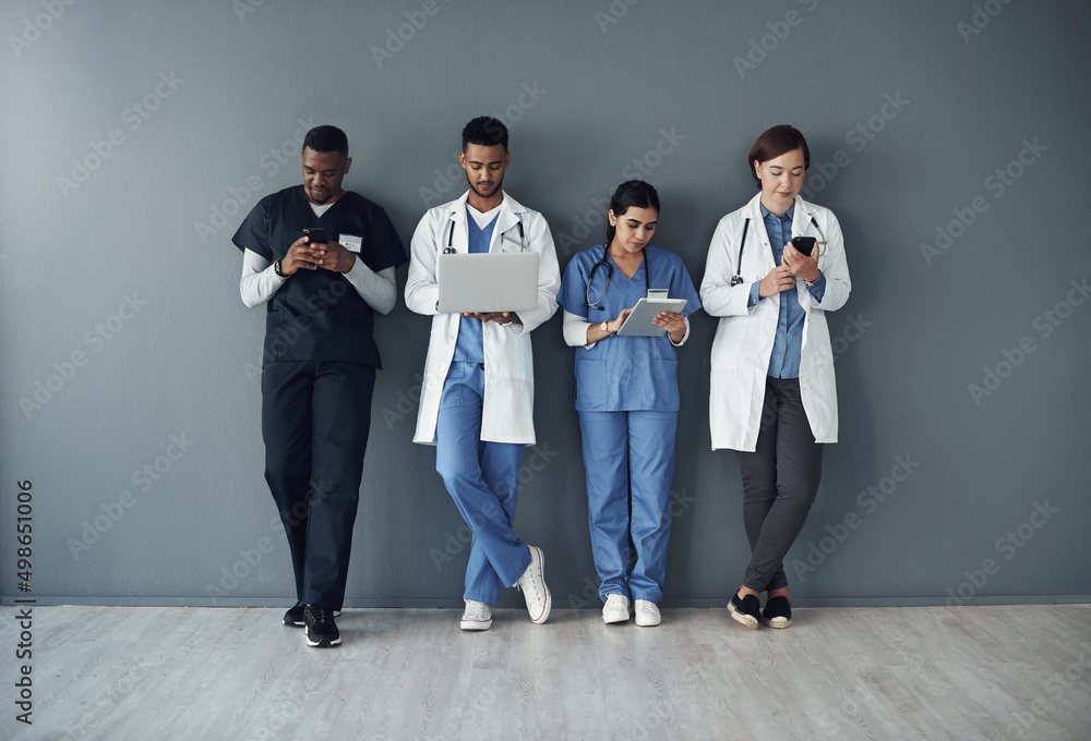 Poster this is actually our lunch break. shot of a group of doctors standing against a grey background at w