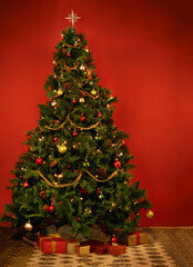 Its Christmastime. Studio shot of a decorated Christmas tree with gifts underneath it.