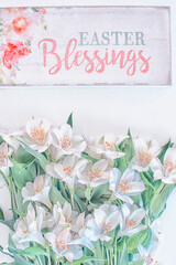  delicate little bouquet of white alstroemeria flowers and a wooden plaque with the inscription in English "Easter Blessing". Spring Easter holiday.
