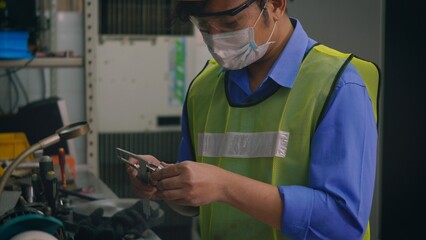 Asian factory worker technician man operating measuring steel size of detail with digital vernier caliper at workshop
