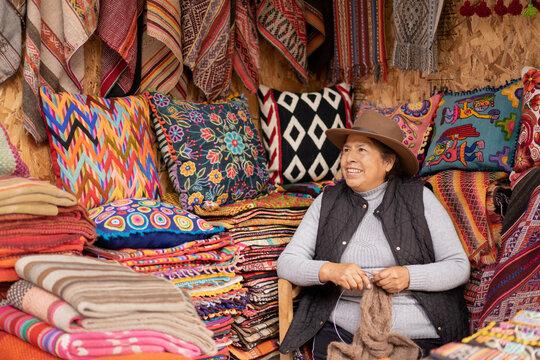 Peruvian woman weaving baby alpaca wool in a handicraft shop