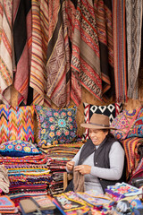 Peruvian woman weaving baby alpaca wool in a handicraft shop