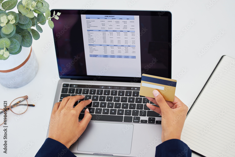 Poster my budget is looking good this month. shot of an unrecognizable person using a laptop to do their bu