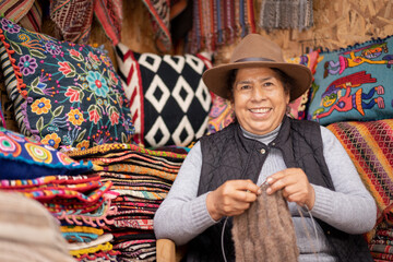 Peruvian woman weaving baby alpaca wool in a handicraft shop