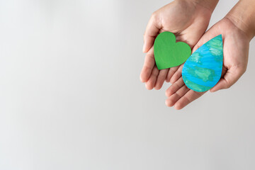 Adult hands holding the water drop and green eco heart on white background.