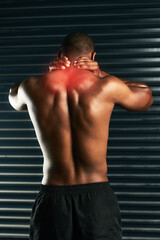 Obraz premium Carrying a little tension in his neck. Rearview shot of an athletic young man holding his neck in pain during a workout.