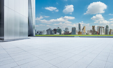 Perspective view of empty concrete tiles floor with city skyline