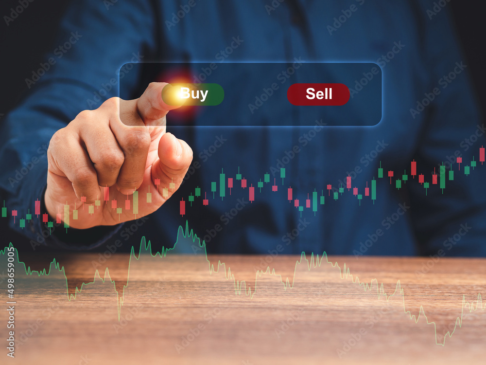 Poster hand of a businessman pointing to buy button on graph stock on virtual screen while sitting on the t