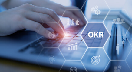 OKR text (Objectives, Key and Results) Working on computer with OKR, business goal, process, outcome. Focused on common goals. Achieve business growth by flexible management. Drive performance growth.