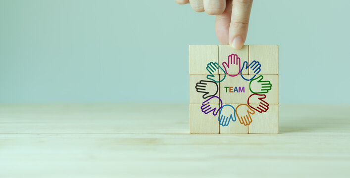 Team building and diversity concept. Common goals and collaboration team for achieving goal Productive people skills. Hand placed wooden cubes with TEAM text and team diversity icons. Teamwork banner.