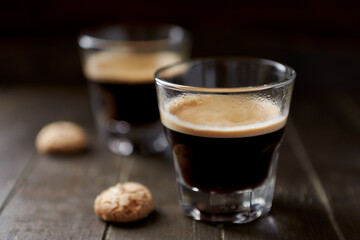 Two Glasses Of Coffee  with Amaretti (Italian biscuits) on dark wooden background. Close up. 