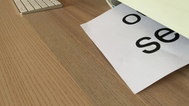 Printing &ldquo;out of service&rdquo; text written message on paper sheet document. Close up A4 white page being printed from multifunction printer scanner on wooden desk in office  