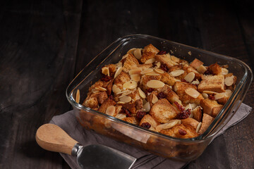 Bread pudding or puding roti tawar topping with almond slice and dried cranberry.