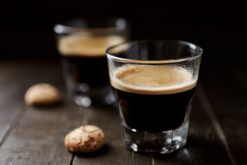 Two Glasses Of Coffee with Amaretti (Italian biscuits) on dark wooden background. Close up.