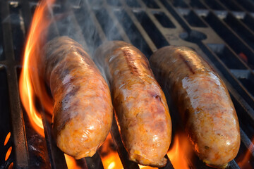 Flame-grilling spicy Italian sausages