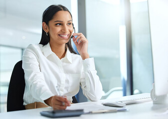 Its my job to solve problems. Shot of an attractive young call centre agent sitting in the office and wearing a headset while using her computer.