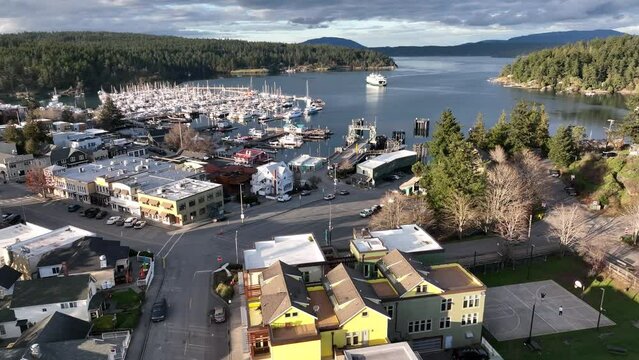 Cinematic 4K aerial drone footage of the arriving WSDOT ferry at the Port and town of Friday Harbor with the ferry terminal, commercial zone, Front Street in the San Juan Islands