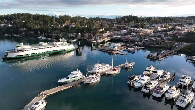 Cinematic 4K aerial drone footage of ferry arriving at the slip in the Port and town of Friday Harbor with the ferry terminal, commercial zone, downriggers in the San Juan Islands