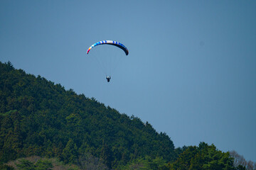 穏やかな日差しの中をパラグライダー