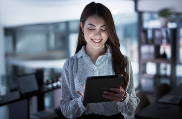 Digitising her way to the deadline. Shot of a young businesswoman using a digital tablet in an...