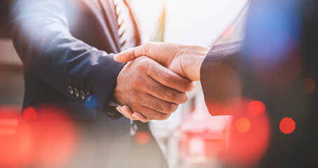 Businessman and businesswoman shaking hands with bokeh city backgrounds, business deals and...