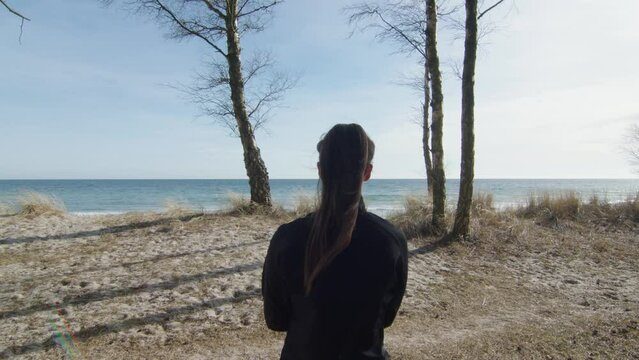 Young woman watching ocean horizon looking around tropical beach glade. Sunny warm weather blue sky emerald sea white fine sand. Static shot with still calm model. Slow motion high quality. Ysad, Swe