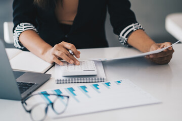 Close up Business woman hand using calculator to calculate the company's financial results and budget. Account Audit Concept.