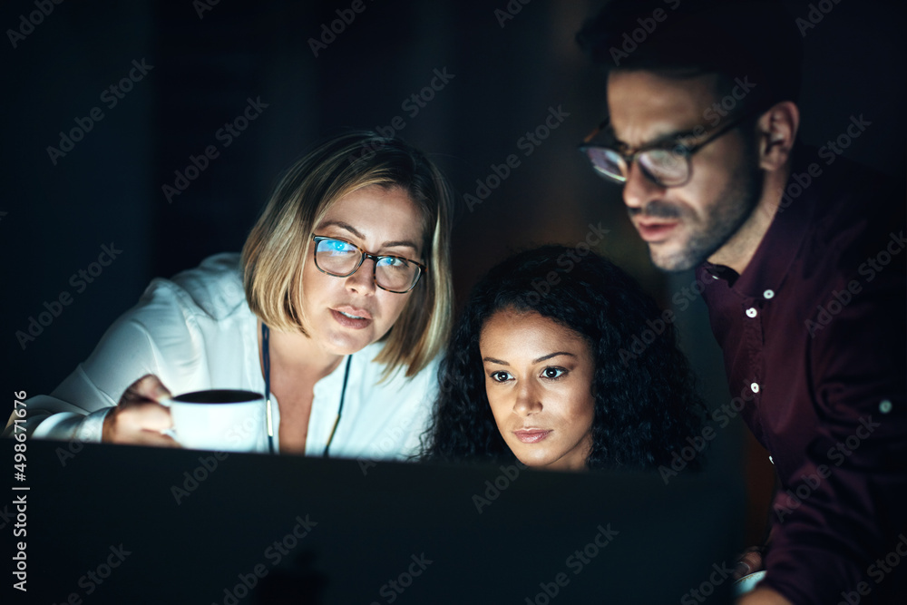 Leinwandbilder the night shift team knows how to get things done. shot of a group of colleagues using a computer to